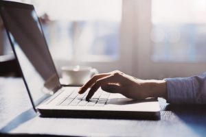 Human hand on laptop keyboard