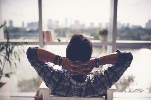 Man relaxing in his chair and enjoying the view from office window