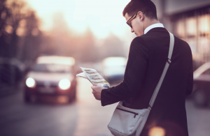 man reading a magazine while walking