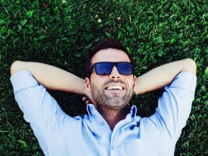 man laying on the ground with sunglasses